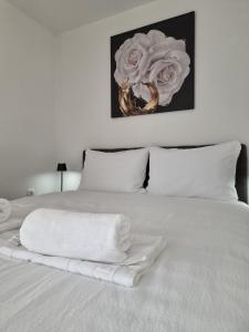 a white bed with white pillows and a painting on the wall at Apartmani Lucica in Jajce +40 photos