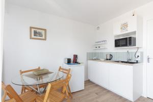 a kitchen with a glass table and chairs in a room at Studio à 50 m de la plage in Arcachon