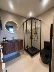 a bathroom with a shower and a toilet and a sink at Hadrians Hotel in Chesters +30 photos