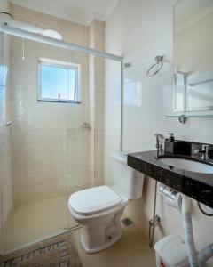 a bathroom with a shower and a toilet and a sink at Souza Apart 1 - Apartamentos completos com muito aconchego in São Thomé das Letras +71 photos