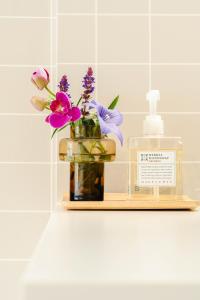 a shelf with a bottle of perfume and flowers at Maison Atago201 in Fukuoka