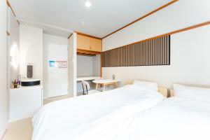 a bedroom with two white beds and a table at Maison Atago201 in Fukuoka +42 photos