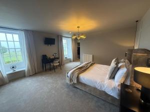 a bedroom with a bed and a desk in it at Hadrians Hotel in Chesters