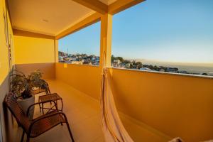 a balcony with two chairs and a view of the ocean at Souza Apart 1 - Apartamentos completos com muito aconchego in São Thomé das Letras