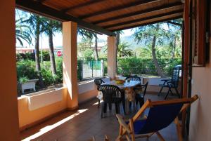 un patio con mesa, sillas y árboles en Casa Vacanze Rosa dei Venti - Clima, terrazze e biciclette en Campo nell'Elba