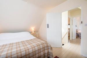 a white bedroom with a bed and a hallway at The Nant in Haverfordwest
