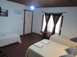 a room with two beds and two windows at YPORA Ldg in Colonia Carlos Pellegrini