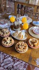 a table with plates of food and glasses of orange juice at YPORA Ldg in Colonia Carlos Pellegrini