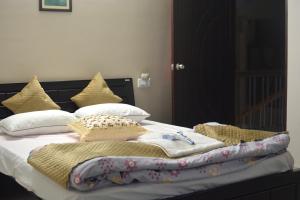 a bed with pillows and a blanket on it at Magpie Residency Kalimpong in Kalimpong