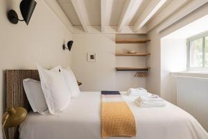 a bedroom with a bed with white sheets and pillows at Le Moulin de Nouara in Ambert +17 photos