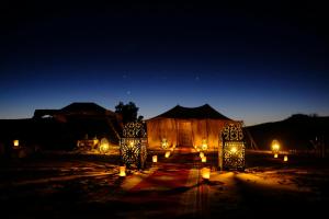 a night view of a large tent with lights at Roaming Desert Luxury Camp in Lac Yasmins +11 photos