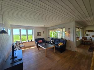a living room with a couch and a table at Spacious foresthouse with stunning view in Ydby