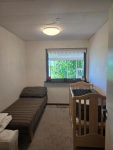 a room with two beds and a window and a crib at Spacious foresthouse with stunning view in Ydby