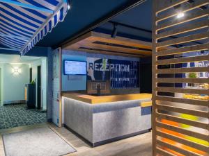 a rendering of the reception desk of a restaurant at Ibis budget Hamburg Quickborn in Quickborn