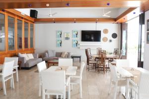 ein Esszimmer mit weißen Stühlen und Tischen und einem Sofa in der Unterkunft Senator Hotel Apartments - Adults Only in Ayia Napa