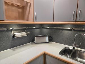 a kitchen counter with a sink and a toaster at Spacious foresthouse with stunning view in Ydby +63 photos