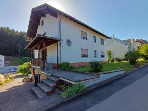 a house with a porch and stairs on a street at Adelheids Apartment in Lützelbach
