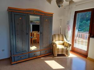 a living room with a cabinet and a chair at Adelheids Apartment in Lützelbach