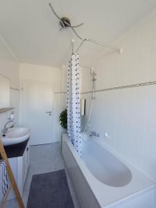 a white bathroom with a tub and a sink at Adelheids Apartment in Lützelbach +17 photos