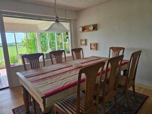 a dining room with a wooden table and chairs at Spacious foresthouse with stunning view in Ydby