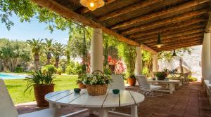 a patio with tables and chairs and a pool at Masia Sitges Mas Peirot Geniune Farmhouse 20 min walk from beaches 60 Heactares of Wine Fields Garden AC Until 18 people in Cubelles +34 photos