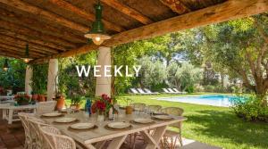 a dining table under a pergola next to a pool at Masia Sitges Mas Peirot Geniune Farmhouse 20 min walk from beaches 60 Heactares of Wine Fields Garden AC Until 18 people in Cubelles