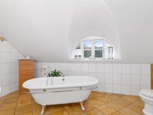 a white bathroom with a tub and a toilet at Holiday Home Jolanda by Interhome in Bramming +42 photos