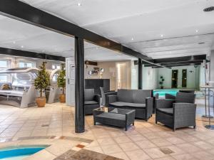 a living room with black furniture and a swimming pool at Holiday Home Jolanda by Interhome in Bramming