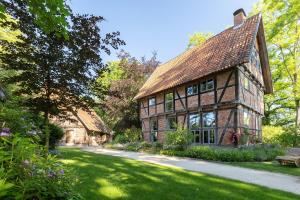 a house with a green yard with a bench at Biohotel WildLand Natural Resort in Hornbostel