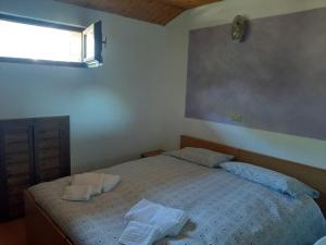 a bedroom with a bed with two towels on it at Albergo Alpino Cheggio in Alpe Cheggio +8 photos