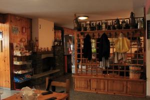 a room with a shelf with bottles of wine at Albergo Alpino Cheggio in Alpe Cheggio
