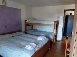 a bedroom with two bunk beds and a mirror at Albergo Alpino Cheggio in Alpe Cheggio