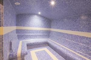 Habitación con baño de azulejos azules con bañera. en Serenity Suites Istanbul Airport en Estambul