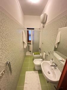 a bathroom with a white toilet and a sink at Da mare in Ginosa Marina