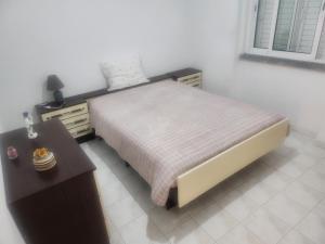 a bedroom with a bed and a dresser and a table at House Proença in Ladoeiro