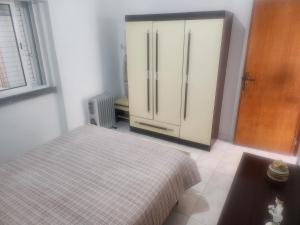 a bedroom with a bed and a large refrigerator at House Proença in Ladoeiro