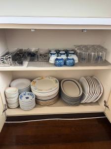a cupboard filled with plates and bowls and dishes at Lemon みやざき in Miyazaki