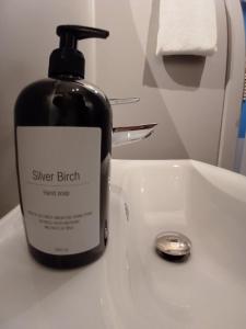 a bottle of sunscreen sitting on a bathroom sink at Blue Double Room 6 on pedestrian street Saeby in Sæby +15 photos