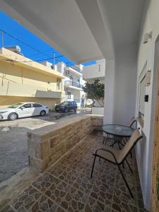a patio with a table and a chair on a building at Lithos Home Agia Galini in Agia Galini