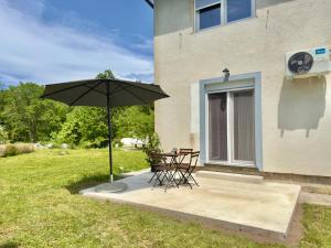 a patio with a table and an umbrella at Cor Montis Apartments in Krasno Polje