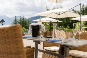 a table with wine glasses and umbrellas at Hotel Zum Stern inkl Gasteiner Bergbahnen im Sommer in Bad Hofgastein