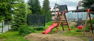 a playground with a slide and a swing set at Pokoje Gościnne Na Wysokim in Bukowina Tatrzańska