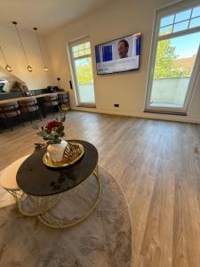 a living room with a table and a tv at Pro Home Elia Maisonette in Bad Oeynhausen