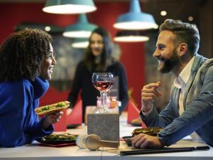 a man and a woman sitting at a table eating food at ibis Coventry Centre in Coventry