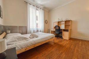 a bedroom with a bed and a desk with a computer at #EU L'Authentique in Grenoble