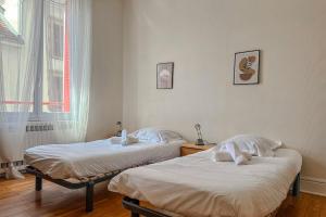 two twin beds in a room with a window at #EU L'Authentique in Grenoble +16 photos