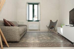 un soggiorno con divano e finestra di Casa LIGNY - charme apartment a Trapani