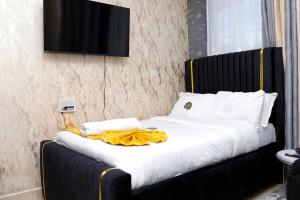 a black and white bed with a yellow blanket on it at JS Urban Stays in Gatunga