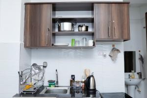 a kitchen with wooden cabinets and a sink at JS Urban Stays in Gatunga