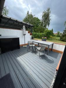 a wooden deck with a table and chairs on it at Haus Sonnenschein in Koserow